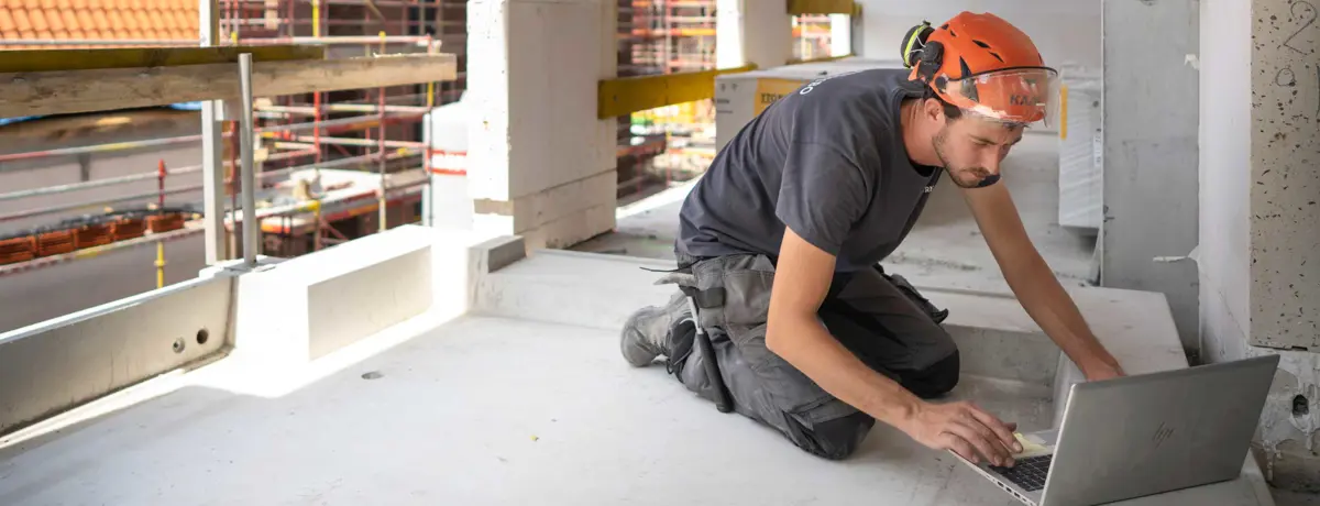 Ingénieur sur chantier en train de regarder son pc